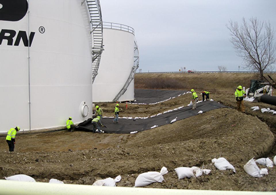 Contaminant liner being installed around fueling tank.